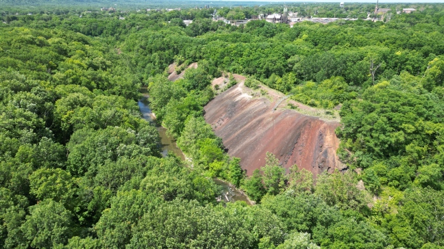 This 17-acre pile of slag and sinter that contains mercury, lead, cadmium and other chemical contaminants and heavy metals borders the Vermillion River at Carus Chemical's manufacturing plant in LaSalle Illinois. The Vermillion River empties into the Illinois River less than two miles from the plant and leads to the Mississippi River, which empties into the Gulf of Mexico, where there is a 6,300 mile dead zone where marine life cannot survive.